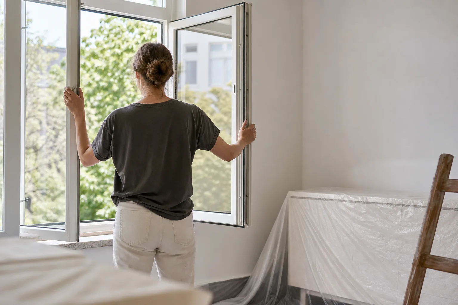 Person öffnet ein Fenster in einem vorbereiteten Innenraum